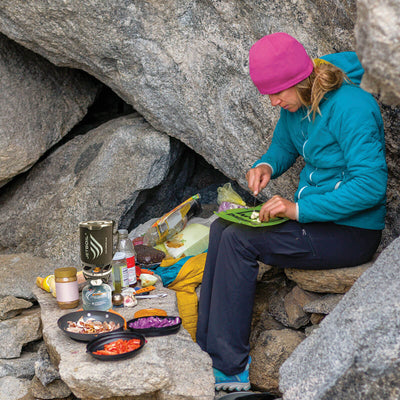 Women cooking with Jetboil MicroMo on rocks outdoors