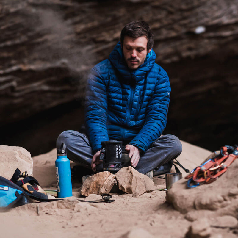 Man cooking on the floor with the Jetboil MicroMo in a cave