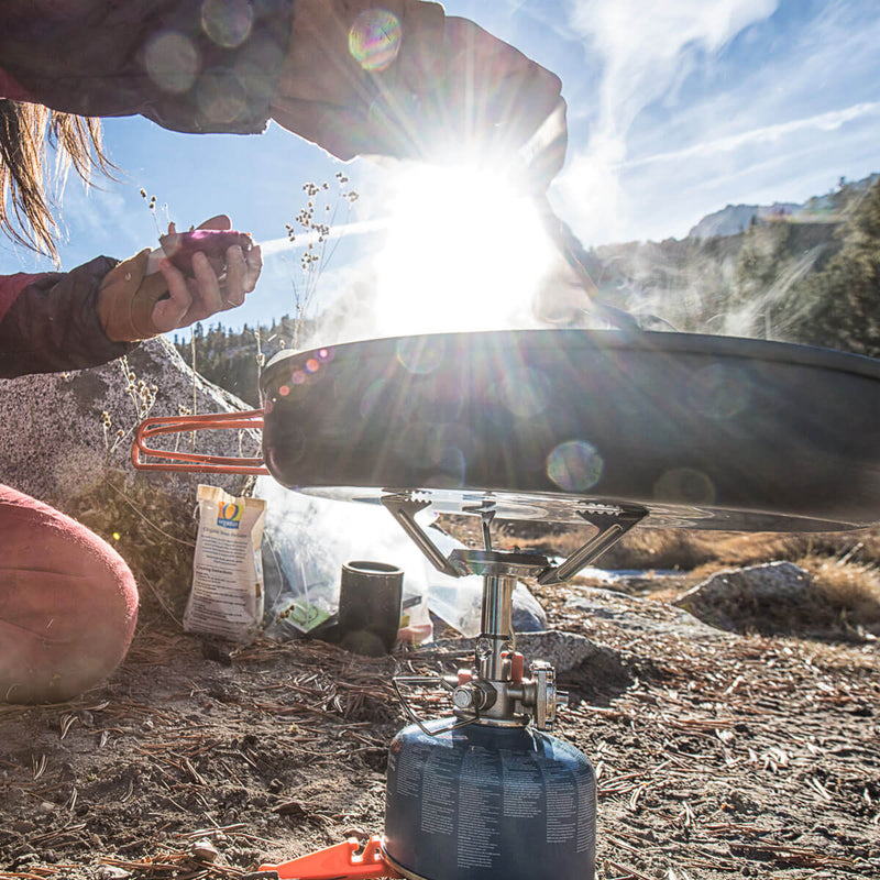 Women cooking with the Jetboil MightyMo on the ground
