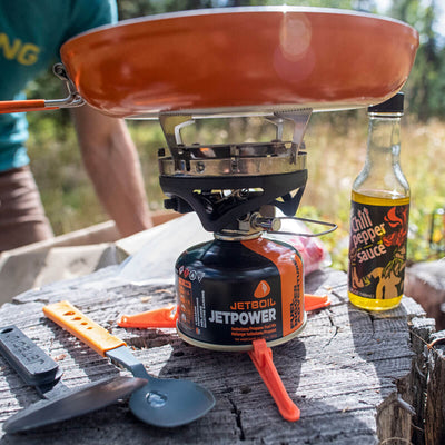 Jetboil 8 Inch Ceramic Summit Skillet cooking on the stove on a tree trunk