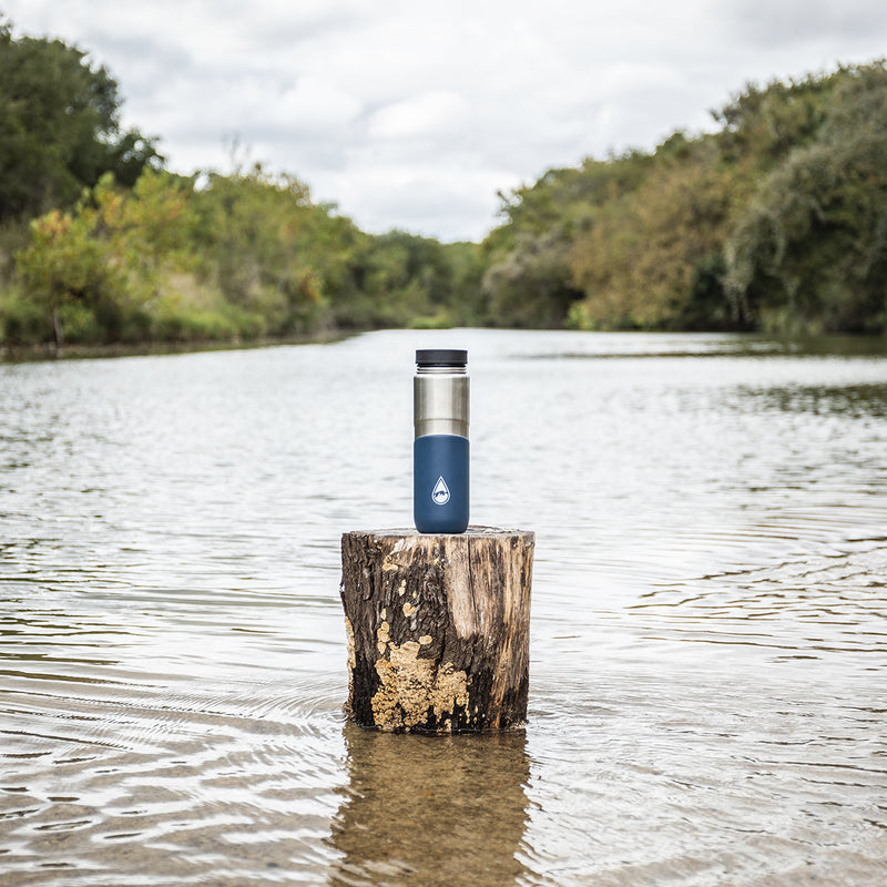 blue Berkey® Lookout™ Bottle on a tree stump in a lake