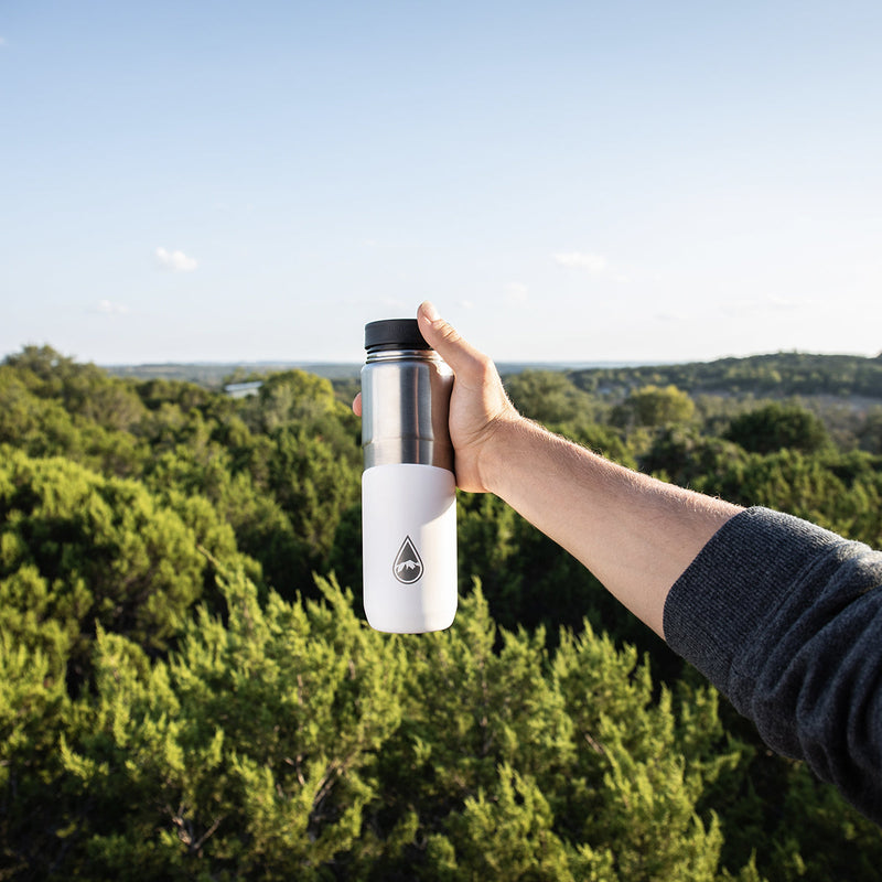 man holding white Berkey® Lookout™ Bottle with tree view
