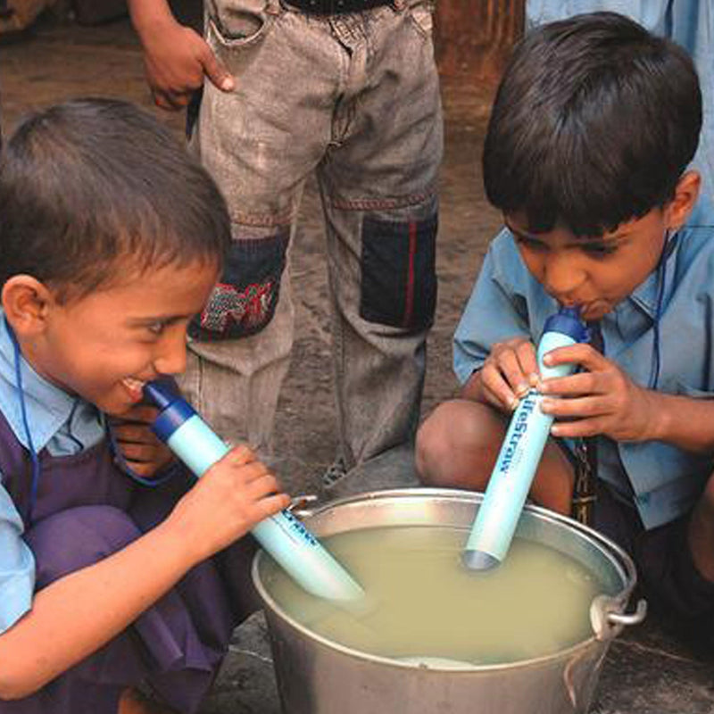 2 boys using lifestraw water filter and drinking from murky water 